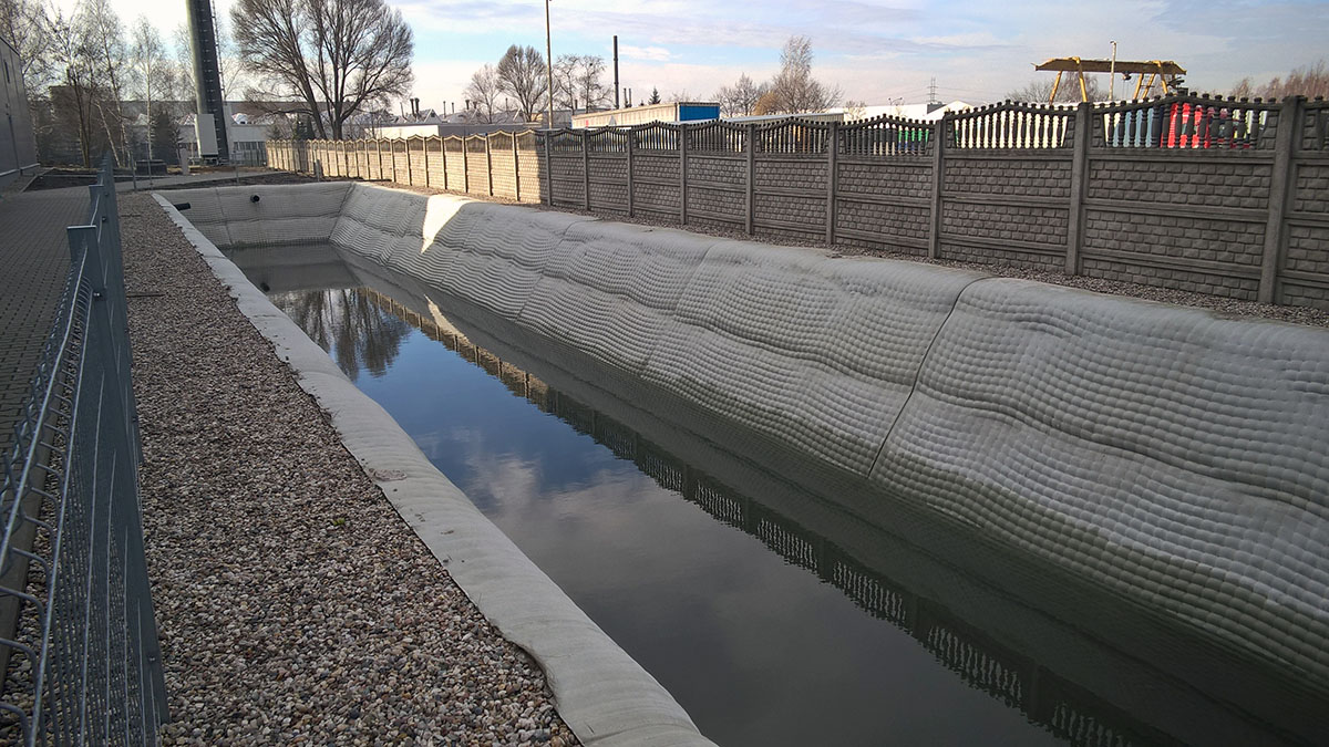 Zbiornik na wody opadowe przy hali produkcyjnej w Sosnowcu, zabezpieczony materacami Incomat Standard - pochylenie skarp 56st